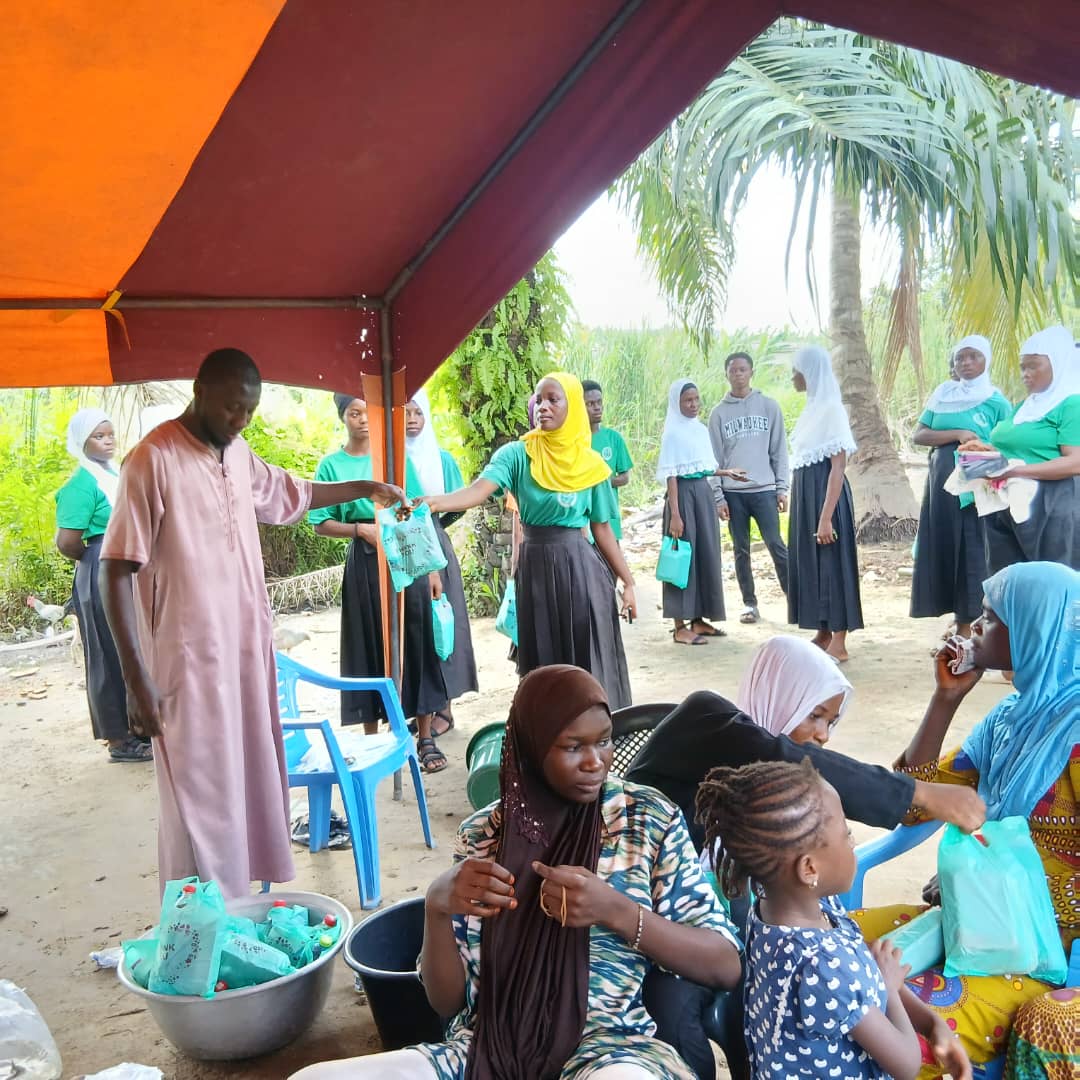 Volunteers sharing food with students in a village