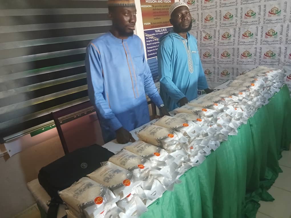 Donations packages lined up for widows and orphans with Sheikh standing in front